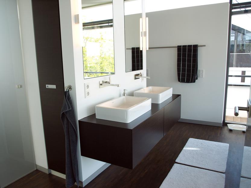 Weißes Doppelwaschbecken über schwarzem Waschbeckenunterschrank in modernem Badezimmer
