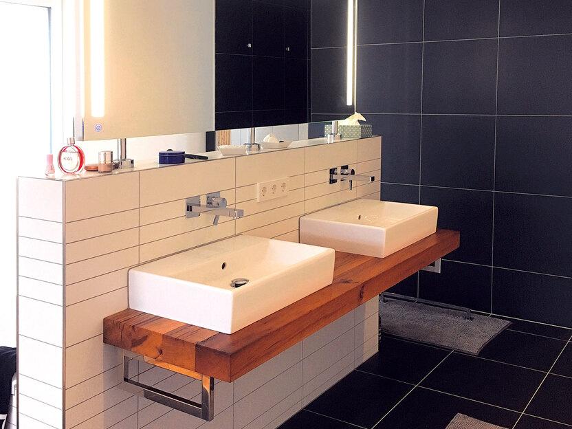 Waschbeckentisch aus Holz unter zwei weißen Waschbecken