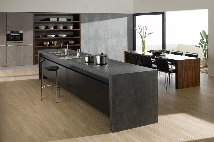 Küchen- und Esszimmerimpression mit einer Kombination aus Holz- und Stein-/ Betonoptik und Einbauschränken