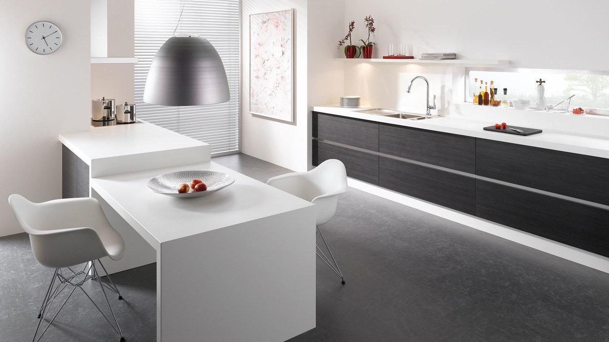Impression einer einzeiligen Küchengestaltung in schwarz-weiß mit Esstisch für Zwei