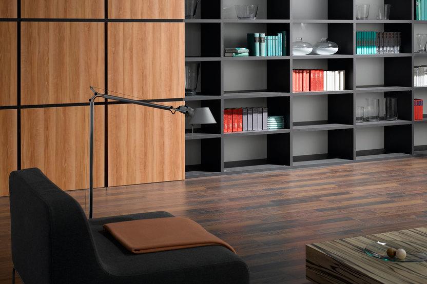 Detailaufnahme eines schwarz lackierten Bücherregals in Kombination mit quadratischen Holztüren für geschlossene Regalseite.